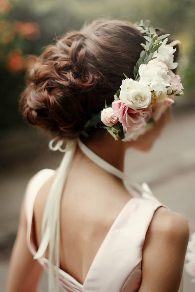 wedding hair style. luxury pink floral wreath on bride hair in tender rich dress at garden